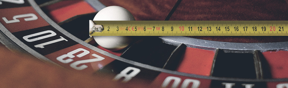 Montaje fotográfico de una ruleta con bola y cinta métrica
