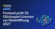 Farbige Spielfichtern neben einem Spielautomaten mit finnischer Flagge im Hintergrund und Kalenderblatt 2027.