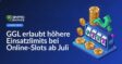 Spielautomat mit leuchtenden Walzen und Münzen vor dunklem Hintergrund, darüber Text "Einsatzlimits ab Juli erhöht"